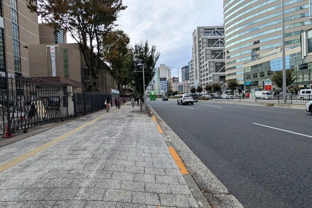 次のツアーに向けて走り去る『ヒトクチヒトイキ旅』バスを見送る写真。緑色の車体が遠くに小さく写っている。